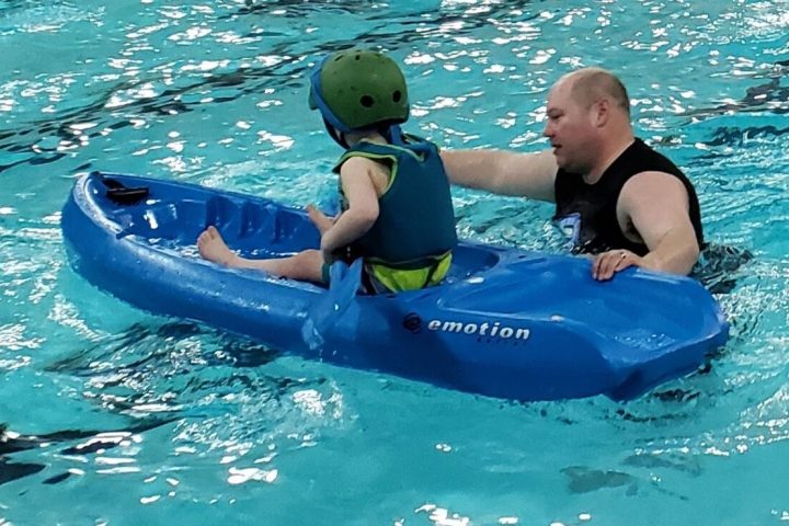 a child paddling in a pool of water